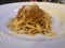 Linguine Bolognese with parmesan cheese , white plate