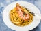 Linguine pasta with tiger prawn sauce in white dish