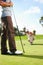 Lining up the perfect putt. Young woman eyeing a hole on the golf course with her husband in the foreground.