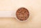 Linseed in measuring spoon on brown background