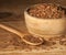 Linseed. Spoon and bowl of linseeds on wooden background