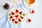 Linzer cookies with heart with raspberry jam and powdered sugar on a white plate with a cup of tea. Dessert on Valentine`s Day.