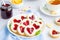 Linzer cookies with heart with raspberry jam and powdered sugar on a white plate with a cup of tea. Dessert on Valentine`s Day.