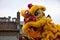 Lion dance costume with traditional chinese house in the background.