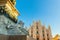 Lion marble statue near famous church Milan Cathedral Duomo di Milano. Panoramic view of top tourist attraction on piazza in Milan