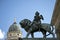 Lion statue with music making cupid at the classical concert hall in Berlin. In the background the dome of the German cathedral.