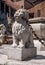 Lion stone statue with metal chain in the mouth, Bergamo town, Italy. Serves as a fencing fountain in the city square