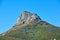 Lions Head mountain with a blue sky and copy space. Beautiful below view of a rocky mountain peak covered in lots of