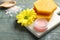 Lip balm, natural beeswax and flower on blue wooden table, closeup