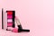 Lip gloss, blusher palette, lipstick on bright pink background. Decorative cosmetics products composition and place for text.