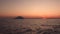 Lipari Island in Mediterranean sea against horizon. Colorful sky, summer sunset or sunrise. Rippling water surface
