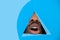 Lips of african-american man peeking throught triangle in blue background