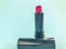 Lipstick on a blue bright matte background. lipstick in a trendy, stylish shade, red. compact lipstick in a black tube. stylish