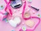 lipstick, eye shadow, cream to create makeup on a pink background with marshmallows, next to a satin ribbon. Beauty industry.