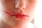 Lipstick smeared on the lips. Young attractive teenager girl doing make-up