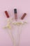 Lipsticks and lip gloss decorate with white dried flowers