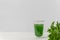 Liquid chlorophyll in a glass cup on white background with space for text