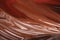 Liquid chocolate flows down. Glossy chocolate surface. Brown background
