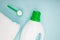 Liquid detergent bottle, powder and white clean towel on blue background