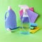 Liquid detergents in plastic bottles, household cleaning products on the table, green background