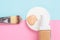 Liquid fluid foundation glass bottle on makeup sponges and egg on pink background