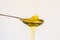 Liquid honey poured onto metal spoon