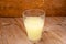 Liquid milk whey in a glass on rustic wooden background. Protein coctail. Dairy food manufacturing concept