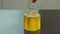 Liquid organic raw honey in glass jar with wooden honey dipper.
