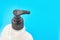 Liquid soap dispenser on blue background. Hygiene to protection from Covid-19. Coronavirus prevention. Closeup