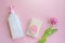 Liquid soap with dispenser for women with a cellulose sponge and pink spring tulip flower on a pink background. cleanser concept.