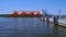 Liquified natural gas tanker ship passing by wharf to enter industrial port on sunny day