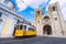Lisbon city and famous yellow tram 28 in front of Santa Maria cathedral