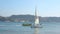 Lisbon, Portugal - July 15, 2019: View of Sailboat sailing by tagus river in Lisbon and Floating Yellow bus Tour on river with tou