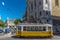 Lisbon, Portugal - May 9th 2018 - Tourist and locals riding a traditional yellow tram in downtown Lisbon, in a beautiful blue sky