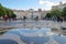 LISBON, PORTUGAL - NOVEMBER 2, 2017: Reflections after rain on the cobbled pavement at Rossio Square with a fountain and colorful