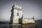 Lisbon Torre de Belem against gray sky, high tide