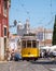 A Lisbon tram carrying passengers in the city with St. Vincent Church in the background