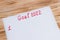 List of New Year`s goals for 2022 on a piece of paper, handwritten on a wood background. Flat style. Plan, strategy, business,