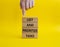 List and prioritize tasks symbol. Concept words List and prioritize tasks on wooden blocks. Beautiful yellow background.