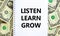 Listen, learn, grow symbol. Words `Listen, learn, grow` on white note. Beautiful background from dollar bills. Business,