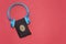 listen to quran concept, holy muslim book and bluetooth headphone isolated on red background.