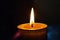 A lit candle flickers against a solid black background, casting a warm glow, Binary flame for a candle on a black background, AI