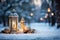 Lit candles and a snow covered lantern create a festive atmosphere in a winter setting