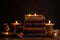 Lit candles surrounded by books on Ayurveda, ancient scriptures and panchakarma rejuvenation therapy. Set a sacred, meditative