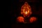 Lit diya lamp against dark background. Lamp made out of silver metal with god statue lit during festival