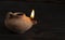 A Lit Handmade Oil Lamp from the Middle East on a Dark Table