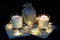 Lit scented wax candles, three pieces, Christmas garland, composition on a black background