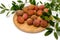 Litchi lie on a wooden plate, around a sprig with leaves on a white background