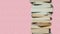 Literature for study: Stack of books; pink background
