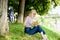 Literature for summer vacation. Summer vacation. Student smart nerd sit on green grass and read book. Girl relaxing at